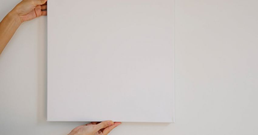 Offers - Unrecognizable female demonstrating empty poster of square shape during advertisement campaign against gray wall