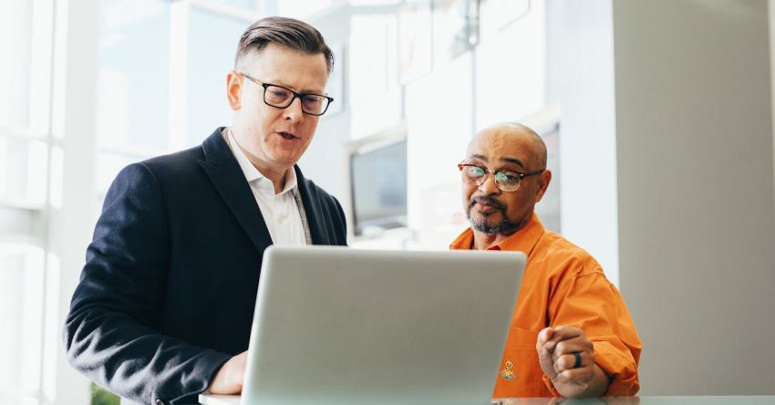 Sales - Man Using Silver Laptop Beside Another Man